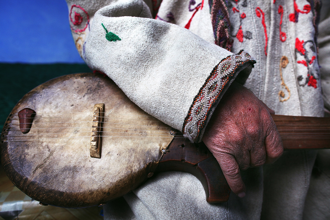 Gros plan sur une main tenue une guitare traditionnelle de la tribu des tadjik au Tadjikistan, extrait du livre Ashayer, nomades