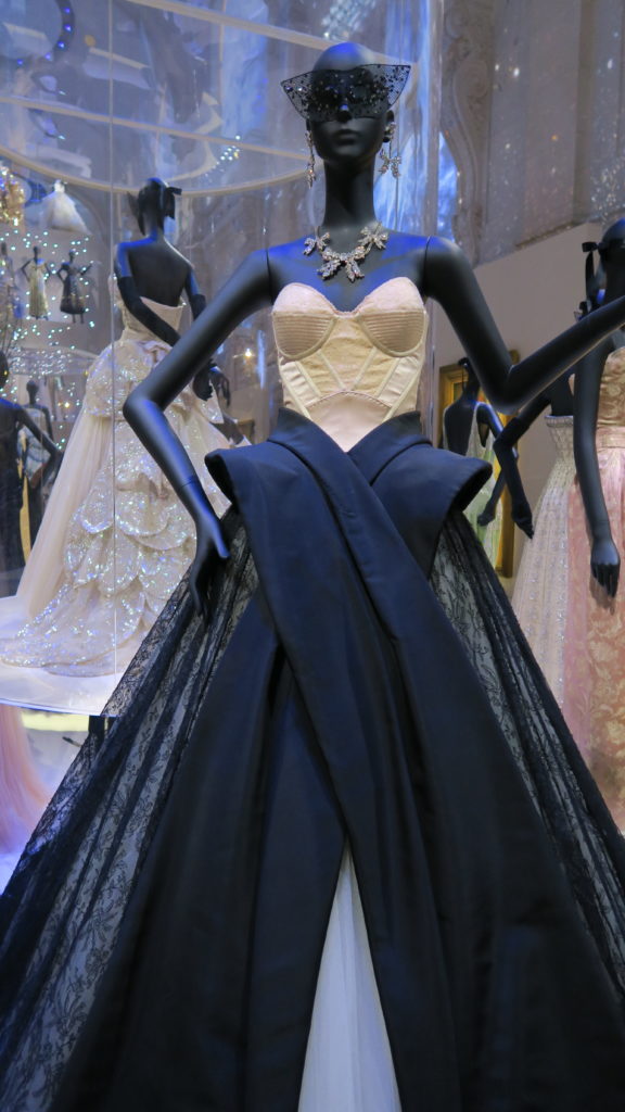 mannequin portant un bustier en soie, une jupe noire et un masque en dentelle Dior