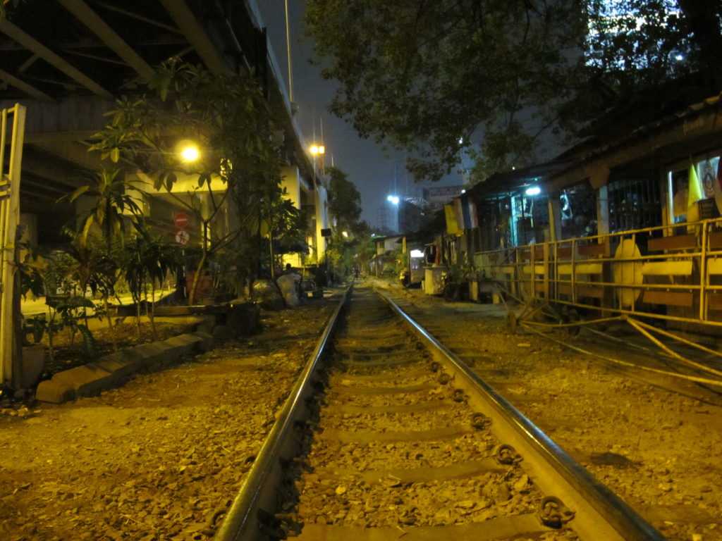 photo de nuit du chemin de fer qui traverse la ville de Bangkok